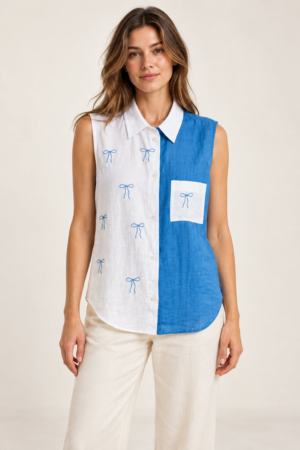 Blue and white sleeveless bow shirt on a model, front view