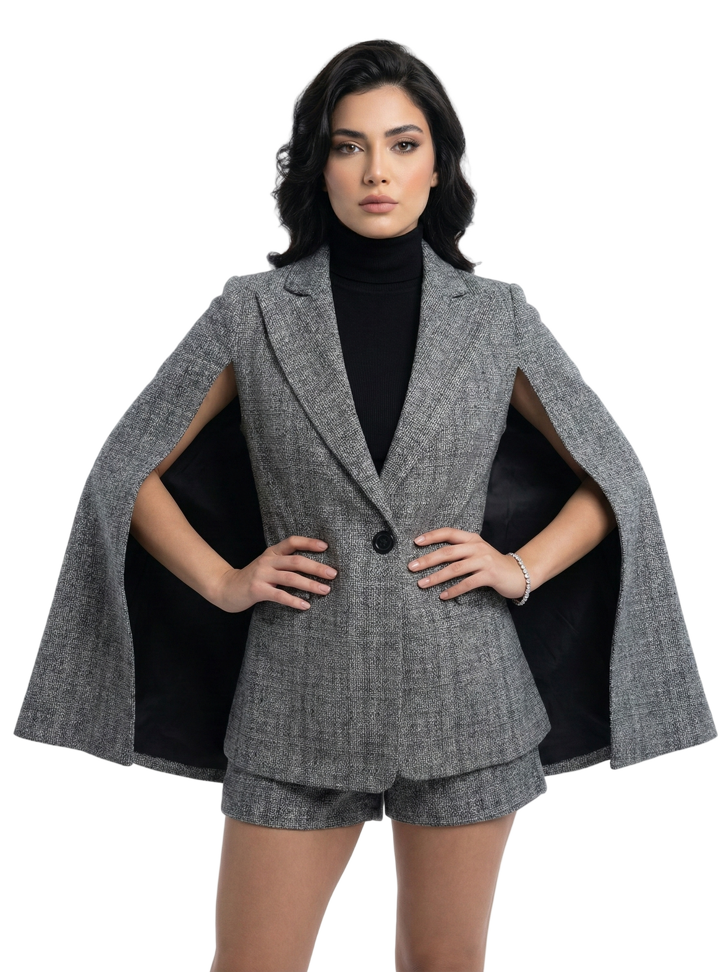 Woman wearing a gray cape over a black outfit on a white background