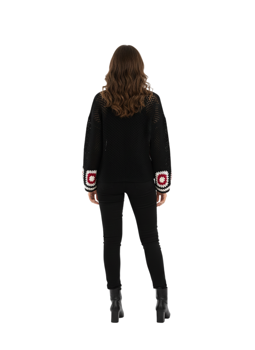 Woman wearing a black sweater with white patterned sleeves on a white background