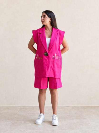 Fuchsia sleeveless embroidered vest and matching shorts set on a model, front view