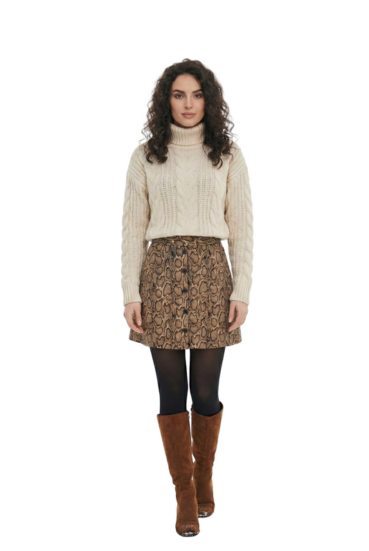Woman wearing a beige sweater, patterned skirt, and brown boots on a white background