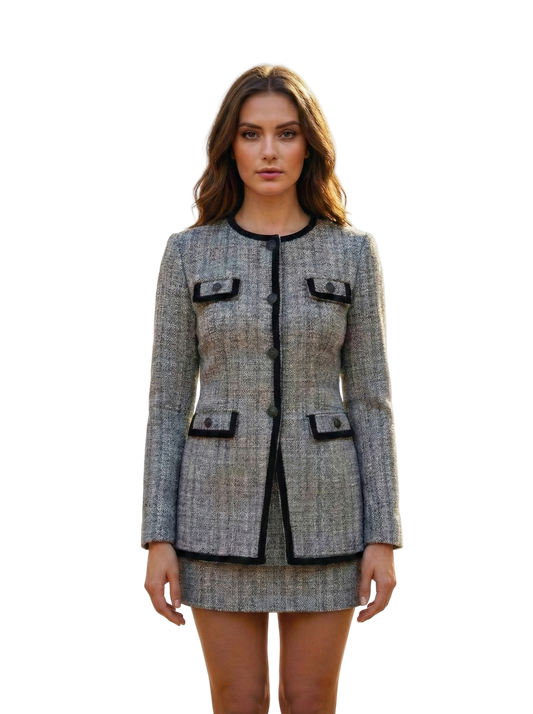 Woman wearing a gray tweed suit with black accents on a white background