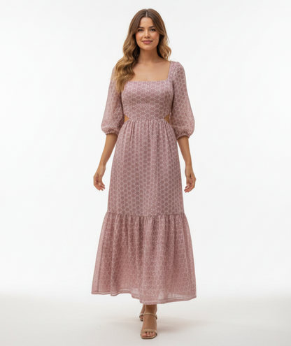 Woman wearing a pink patterned dress on a white background