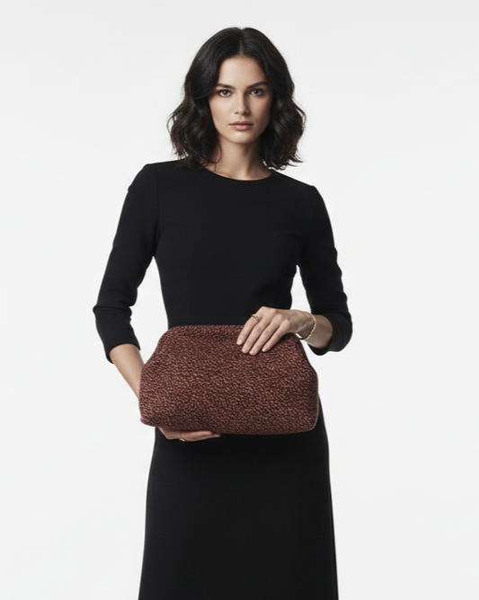 Woman holding a brown clutch bag against a white background